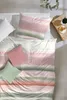 A neatly made bed with a patterned duvet cover and pillows. Produktbild-Vorschau