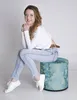 A woman is sitting on a pouf. Produktbild-Vorschau