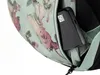 A close-up view of a black portable hard drive being placed into a zippered pocket of a floral-patterned rucksack. Produktbild-Vorschau