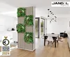 A modern interior with a decorative wall panel featuring artificial plants, a dining table and chairs, and kitchen cabinets. Produktbild-Vorschau