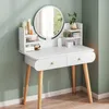 A white dressing table with a round mirror, drawers, and shelves holding cosmetics, set against a light green wall. Anteprima dell’immagine prodotto
