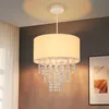 A pendant light fixture with a fabric shade and crystal accents hangs from the ceiling. Náhľad obrázku produktu