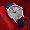 A close-up shot of a Casio watch with a silver dial and a blue leather strap, set against a red background. Voir les images du produit