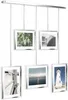 A display of five framed pictures hanging from a rail. Podgląd zdjęcia produktu