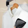 A white shirt is being steamed by a handheld steamer. Produktbild-Vorschau