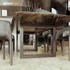 A dining table with marble top and metal legs, surrounded by chairs, in a modern interior. Produktbild-Vorschau