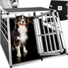 A dog is sitting inside a metal dog crate with the door open.