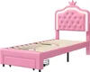 A pink upholstered twin bed frame with a tufted headboard and a crown detail, shown from a side angle against a white background. Voir les images du produit