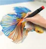 A hand is holding a marker and drawing on a picture of a fish. Produktbild-Vorschau