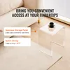 A clear acrylic side table with a cup of coffee on it, placed next to a sofa on a rug. Anteprima dell’immagine prodotto