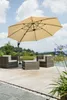 An outdoor patio set with chairs, a table, and a large umbrella, situated on a wooden deck next to a body of water. Produktbild-Vorschau