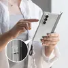 A person is holding a clear phone case with a phone inside, and a decorative lanyard attached. Náhled obrázku produktu