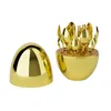 A gold cutlery set with a lid, presented in an egg-shaped holder. Produktbild-Vorschau