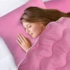 A woman sleeping peacefully on a pink pillow, covered by a pink blanket. Voir les images du produit