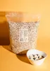 A large bag of oats is shown next to a bowl of oatmeal with fruit. Produktbild-Vorschau