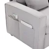 Close-up of the armrest of a gray sofa, showing side pockets with a remote and a magazine inside. Produktbild-Vorschau