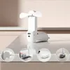 A white handheld fan with USB ports is displayed on a white surface, with smaller circular images below showing different ways to power the fan. Produktbild-Vorschau