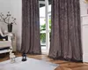 A living room scene with curtains covering a window, a chair, and decorative items. Produktbild-Vorschau