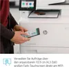A person is using a smartphone to interact with a printer. Podgląd zdjęcia produktu