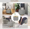 Collage of images showing a gray upholstered ottoman with wooden legs in various settings, demonstrating its storage, seating, and side table functionality. Produktbild-Vorschau