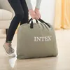A person is holding a folded air mattress in a bag. Náhľad obrázku produktu