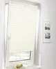 A pleated blind is installed on a window, with a partially open window frame visible. There are two framed pictures on the wall to the right, and a bowl of fruit on the windowsill below the blind. Produktbild-Vorschau