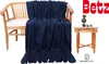 A dark blue fleece blanket draped over a wooden chair, with a small wooden table and decorative plants next to it. The brand logo 'Betz' is visible in the top right corner. Produktbild-Vorschau