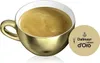 A golden coffee cup filled with coffee and a circular coffee capsule next to it. Produktbild-Vorschau
