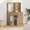 A vanity table with a mirror and lights, a stool, and a plant in a room. Náhľad obrázku produktu