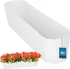 A white oval planter box is shown, with a smaller planter box filled with red flowers in the foreground. Podgląd zdjęcia produktu