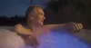 A man relaxing in a hot tub at night. Produktbild-Vorschau