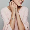 A woman wearing a pink top is shown with her hands near her face, displaying a bracelet with a hot air balloon charm. Produktbild-Vorschau