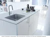 A modern kitchen island with a sink and faucet, featuring some kitchenware and a bowl. Produktbild-Vorschau