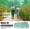 Two people are walking in a greenhouse filled with tomato plants. The image also includes a diagram of the greenhouse. Podgląd zdjęcia produktu