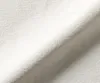 A close-up shot of a textured, light beige fabric, likely upholstery or textile material, folded to show its surface and texture. Produktbild-Vorschau