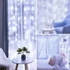 Collage of images showing white LED curtain lights used as decoration in different settings, including draped over curtains, on a side table, and over a bed. Náhled obrázku produktu