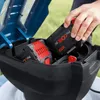 A person is inserting a battery into a Bosch lawnmower. Voir les images du produit