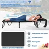 A woman relaxing on a black foldable sun lounger on a beach. Produktbild-Vorschau