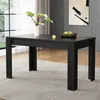 A black rectangular dining table with fluted legs is shown in a dining room setting. The table has a vase with plants and a bowl of fruit on it. A painting hangs on the wall behind the table. Anteprima dell’immagine prodotto