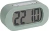 A green digital alarm clock is shown against a light gray background. Podgląd zdjęcia produktu