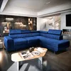 A spacious living room featuring a large blue sectional sofa, a coffee table, and a spiral staircase in the background. Podgląd zdjęcia produktu