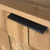 A close-up of a wooden cabinet with a black handle. Anteprima dell’immagine prodotto