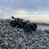 A remote-controlled car is positioned on a pile of gravel with a cloudy sky in the background. Náhľad obrázku produktu