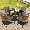 A four-person outdoor dining set with a round table and four chairs on a wooden deck, with a grassy area in the background. Náhled obrázku produktu
