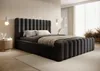 A bedroom scene with a large, dark upholstered bed as the focal point. Produktbild-Vorschau
