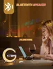 A woman is using a laptop and talking on her phone in a dimly lit room, with a decorative lamp and a glass of wine on the table. Produktbild-Vorschau