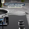 A close-up shot of a stainless steel frying pan on a black induction stovetop, with blue flames visible under the pan. Produktbild-Vorschau