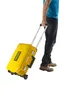 A person is pulling a yellow tool case with wheels. Voir les images du produit