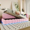 A pink upholstered bed frame with the mattress lifted to reveal storage space underneath. The bed has LED lighting along the base and is placed on a rug in a bedroom setting. Produktbild-Vorschau