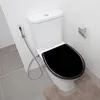 A toilet with a black seat in a bathroom. Produktbild-Vorschau